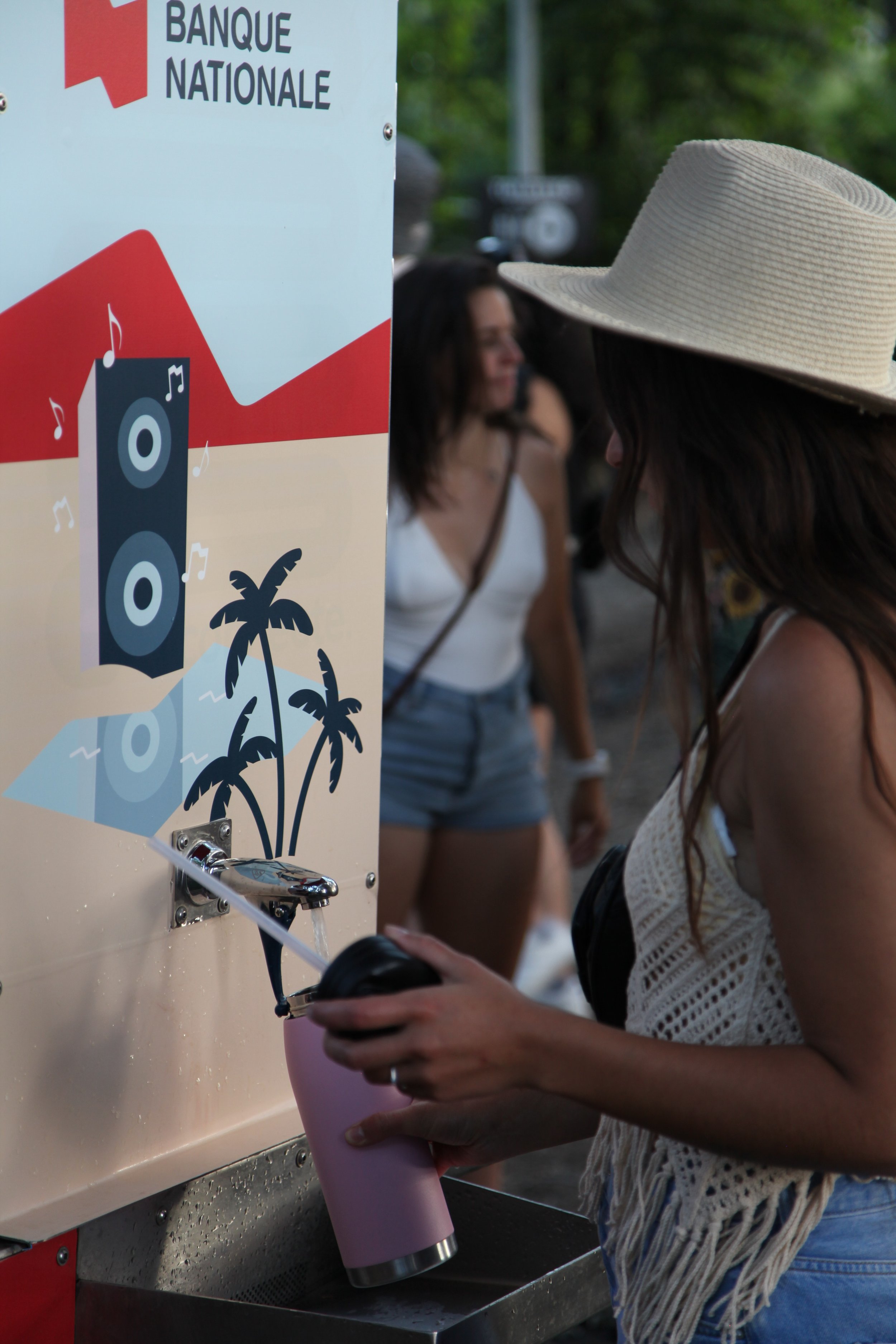 A guest refilling a reusable bottle in seconds at a branded O'land water station