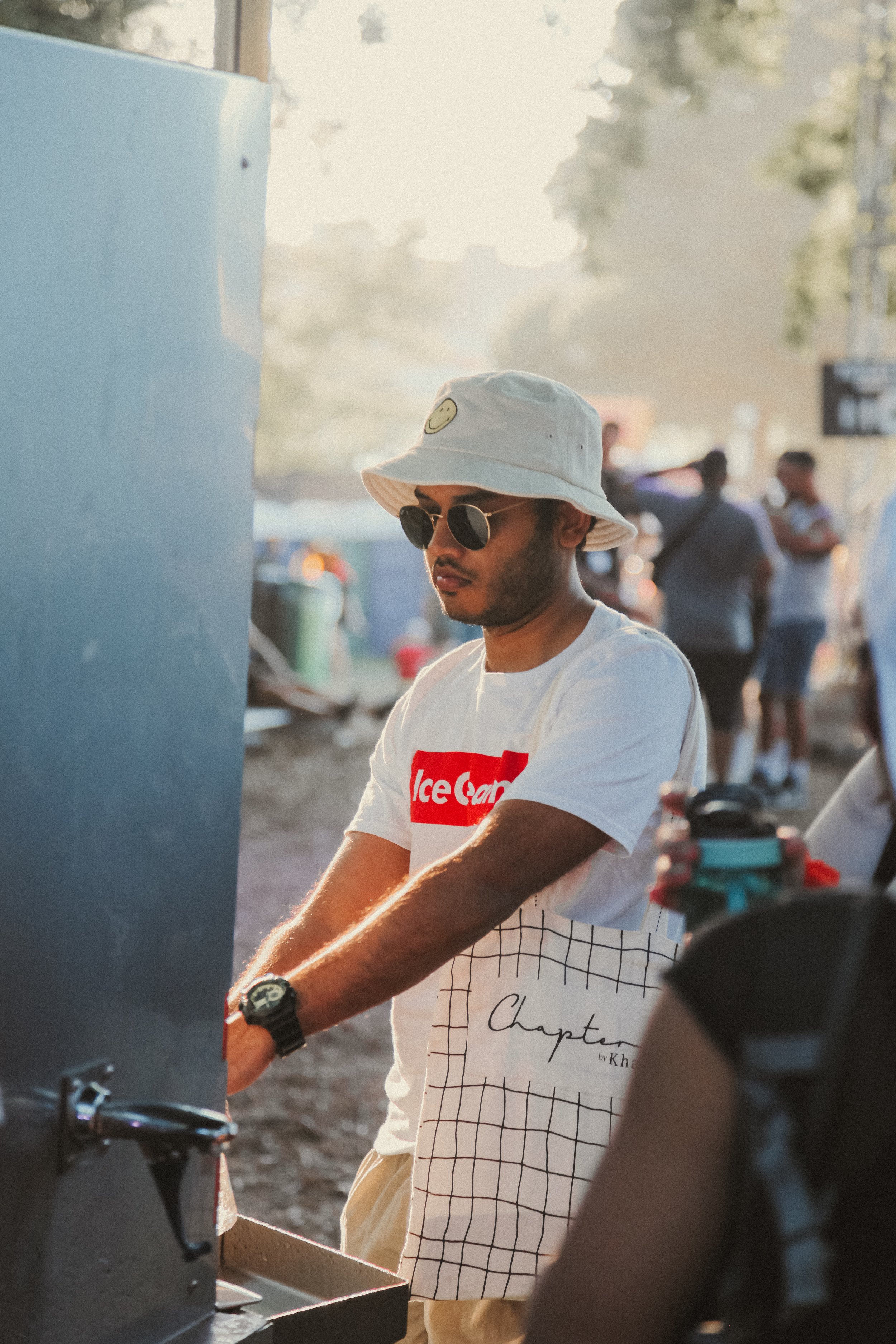 A young man at a festival near a water filling station